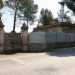 Foto 7. Non ci resta che continuare a passeggiare sul marciapiede, per ritrovare sulla sinistra una villa in evidente stato di abbandono, anche se le due colonne e il cancello bianco arrugginito sui cui si distinguono due grandi lettere maiuscole (T e R), conservano comunque una certa eleganza